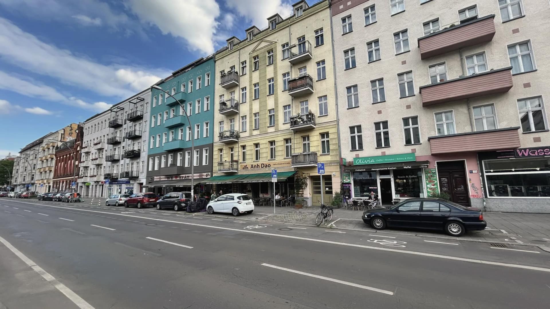 Straßenzug mit Gründerzeithäusern in Prenzlauer Berg, im Erdgeschoss Ladenlokale und Gastronomie